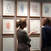 A man and a woman standing in front of a paintings